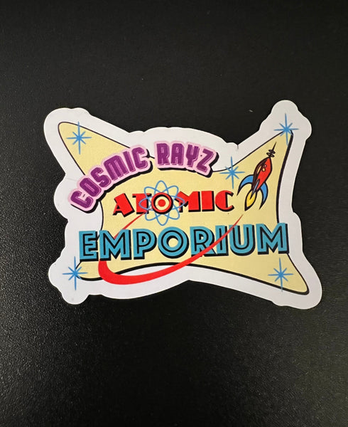 Pegatina pequeña con el logotipo de Atomic Emporium de Cosmic Rayz