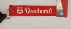 Llavero bordado en blanco y rojo con el logotipo de Beechcraft